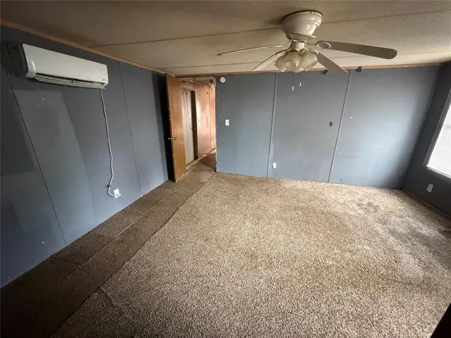 a view of a livingroom with a chandelier fan and wooden floor