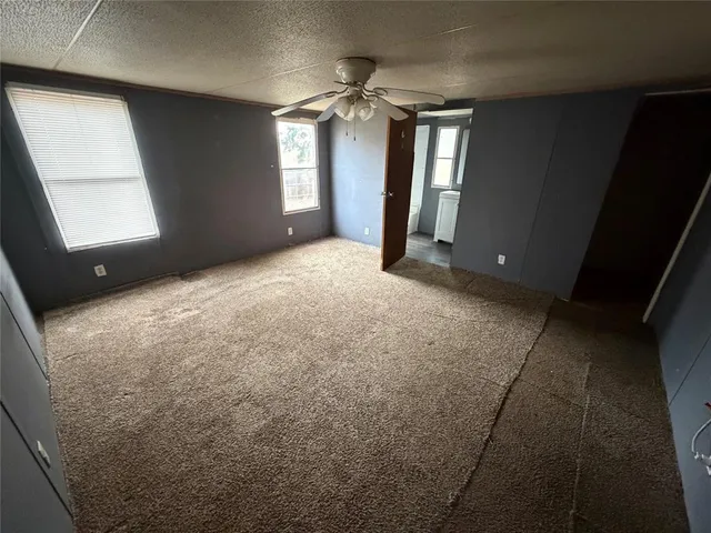 a view of a hallway with windows and chandelier