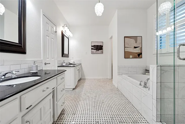 a bathroom with a granite countertop sink a toilet a mirror a bathtub and shower