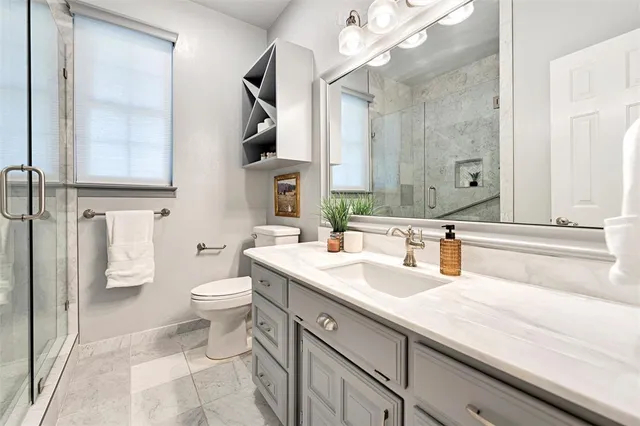 a bathroom with a sink a toilet and a mirror