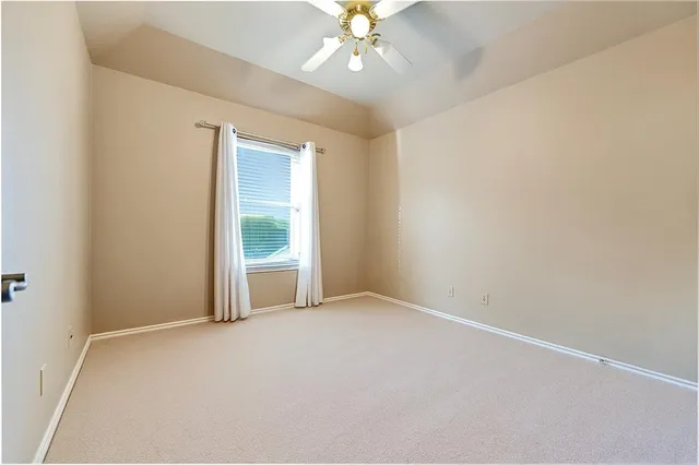 an empty room with a fan and a window