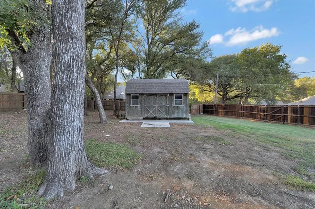 a view of a house with backyard and a tree