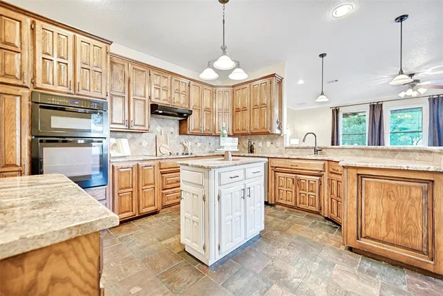a kitchen with granite countertop a sink stainless steel appliances and cabinets