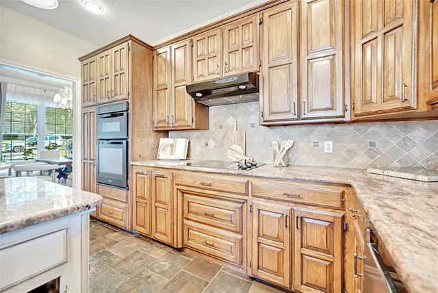 a kitchen with stainless steel appliances granite countertop a sink and cabinets