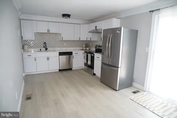 a kitchen with a refrigerator sink and cabinets