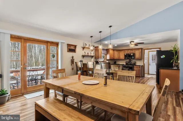 a kitchen with stainless steel appliances kitchen island granite countertop a table chairs and a refrigerator