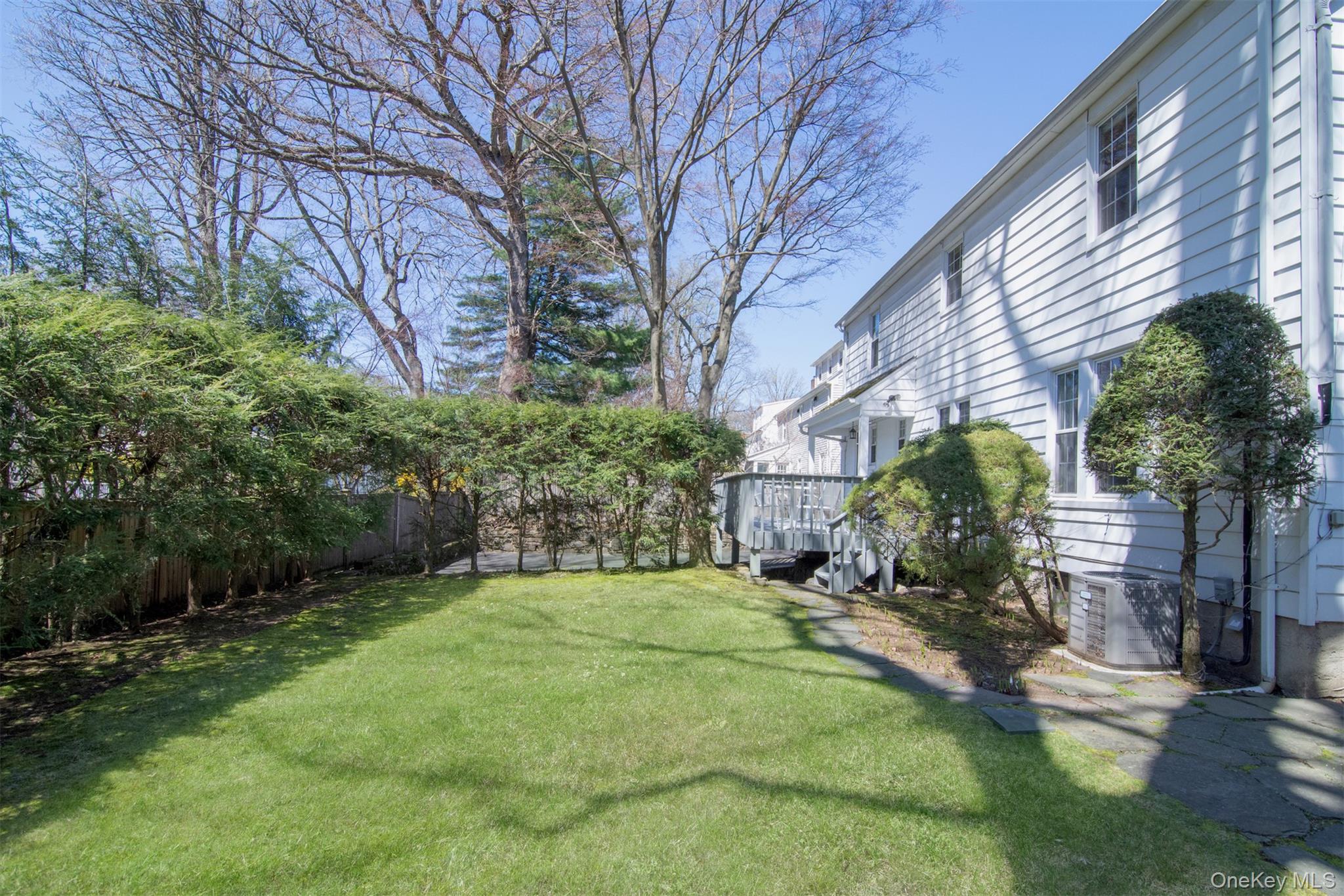 22 Burkewood Road Mount Vernon, NY 10552 - Photo 26 of 27 a backyard of a house with large trees and outdoor seating