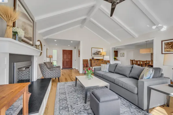 a living room with furniture a fireplace and a floor to ceiling window