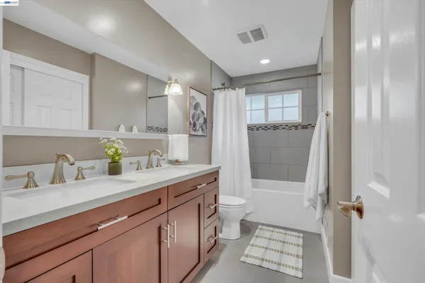 a bathroom with a granite countertop sink toilet and mirror