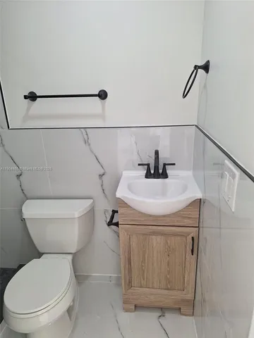 a white toilet sitting next to a shower