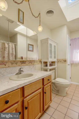 a bathroom with a granite countertop sink mirror vanity and toilet