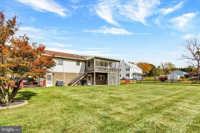 a view of a house with a big yard and large trees
