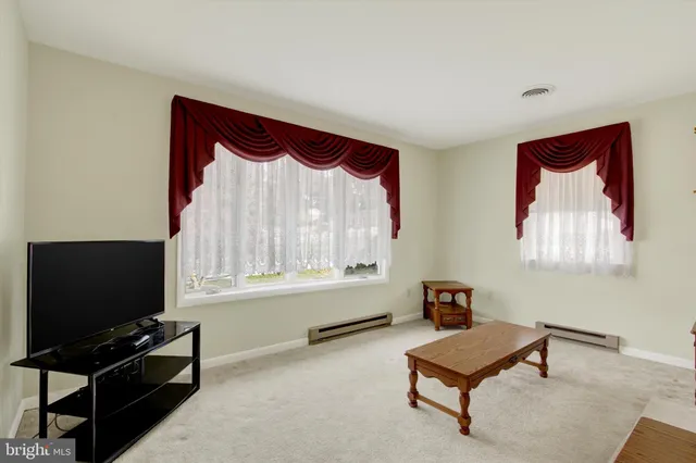 a living room with furniture a flat screen tv and a window