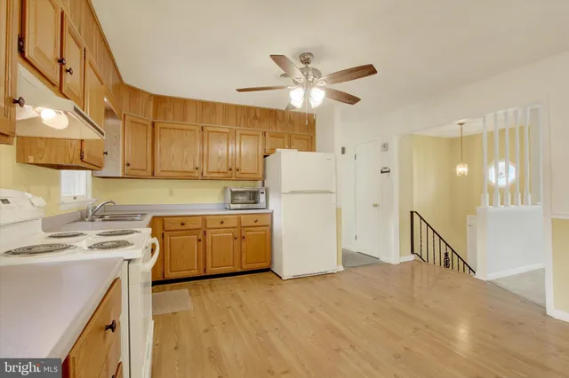 a kitchen with a refrigerator a sink dishwasher with a dining table and chairs