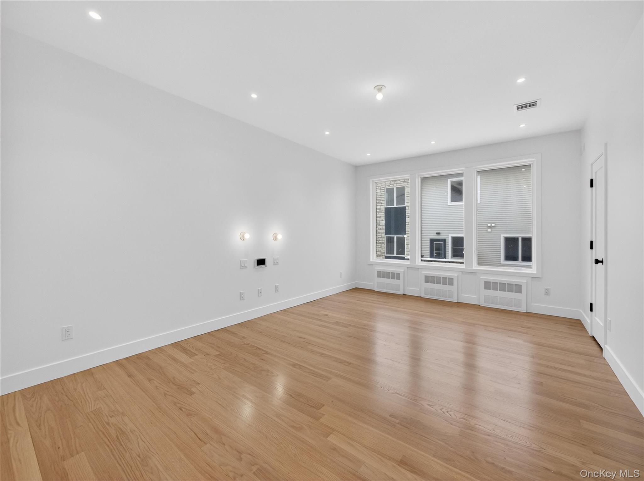 13 Elener Lane, Unit 202 Spring Valley, NY 10977 - Photo 13 of 48 a view of empty room with wooden floor and windows