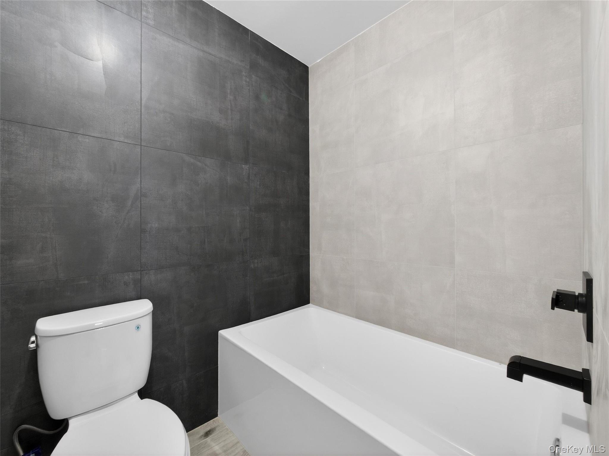 13 Elener Lane, Unit 202 Spring Valley, NY 10977 - Photo 41 of 48 a white toilet sitting next to a bath tub