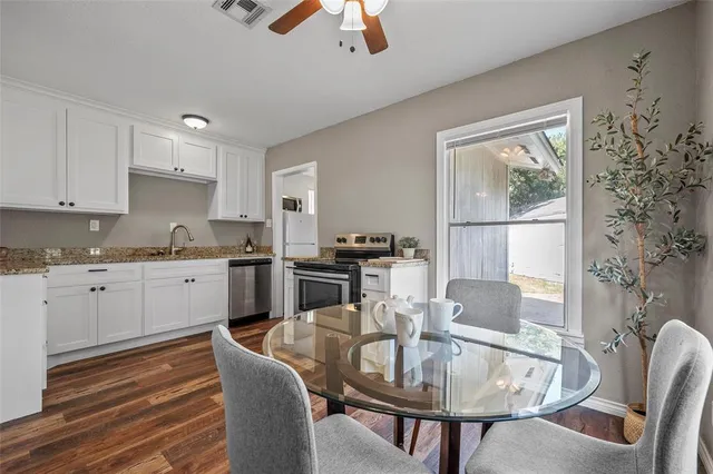 a kitchen with granite countertop white cabinets and stainless steel appliances