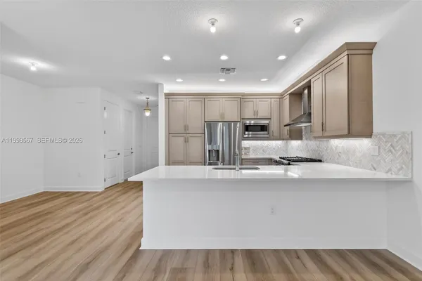 a large kitchen with kitchen island a sink stainless steel appliances and cabinets