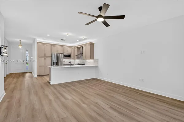 a view of kitchen with stainless steel appliances refrigerator oven and white cabinets