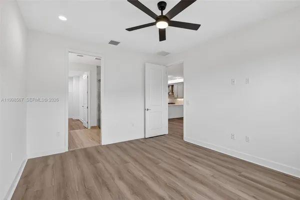 an empty room with closet and a ceiling fan