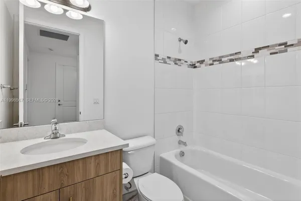 a bathroom with a sink toilet a mirror and shower