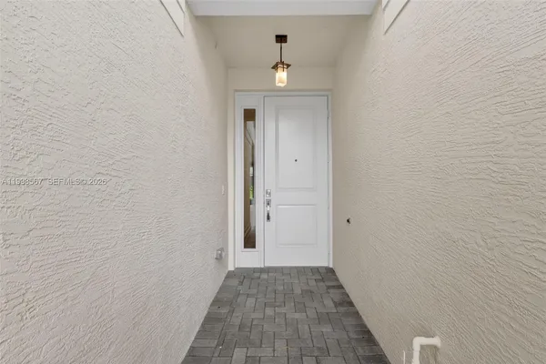 a view of a hallway with wooden floor and a ceiling fan