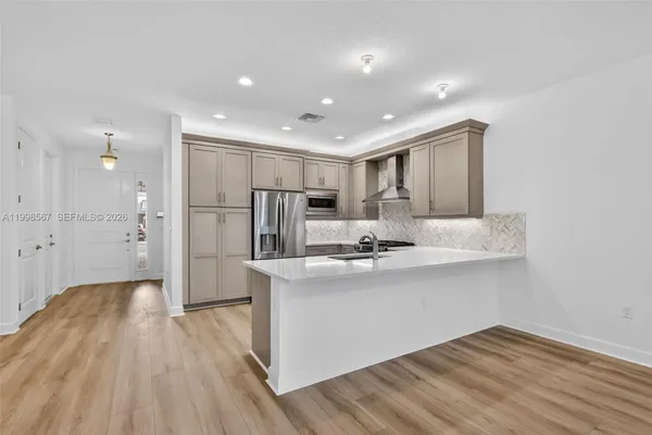 a kitchen with kitchen island white cabinets and stainless steel appliances