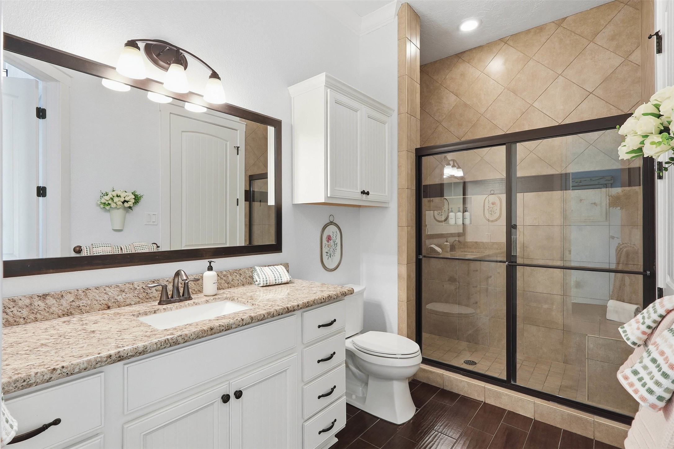 11622 Beachside Galveston, TX 77554 - Photo 10 of 39 This bathroom features a large granite countertop with ample cabinet space, a spacious walk-in shower with sliding glass doors, and elegant tile work.