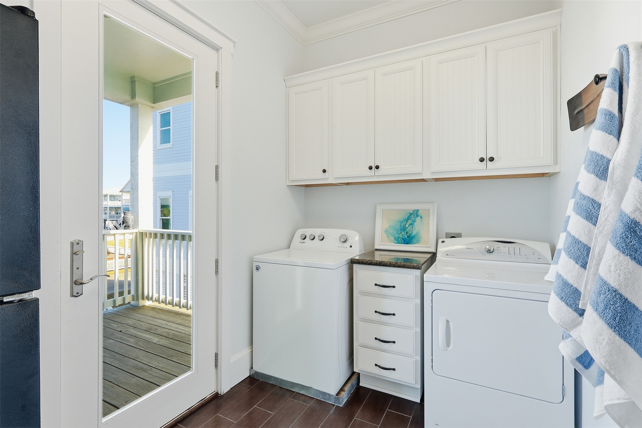 11622 Beachside Galveston, TX 77554 - Photo 11 of 39 This is a bright and functional laundry room featuring white cabinetry and a side-by-side washer and dryer.