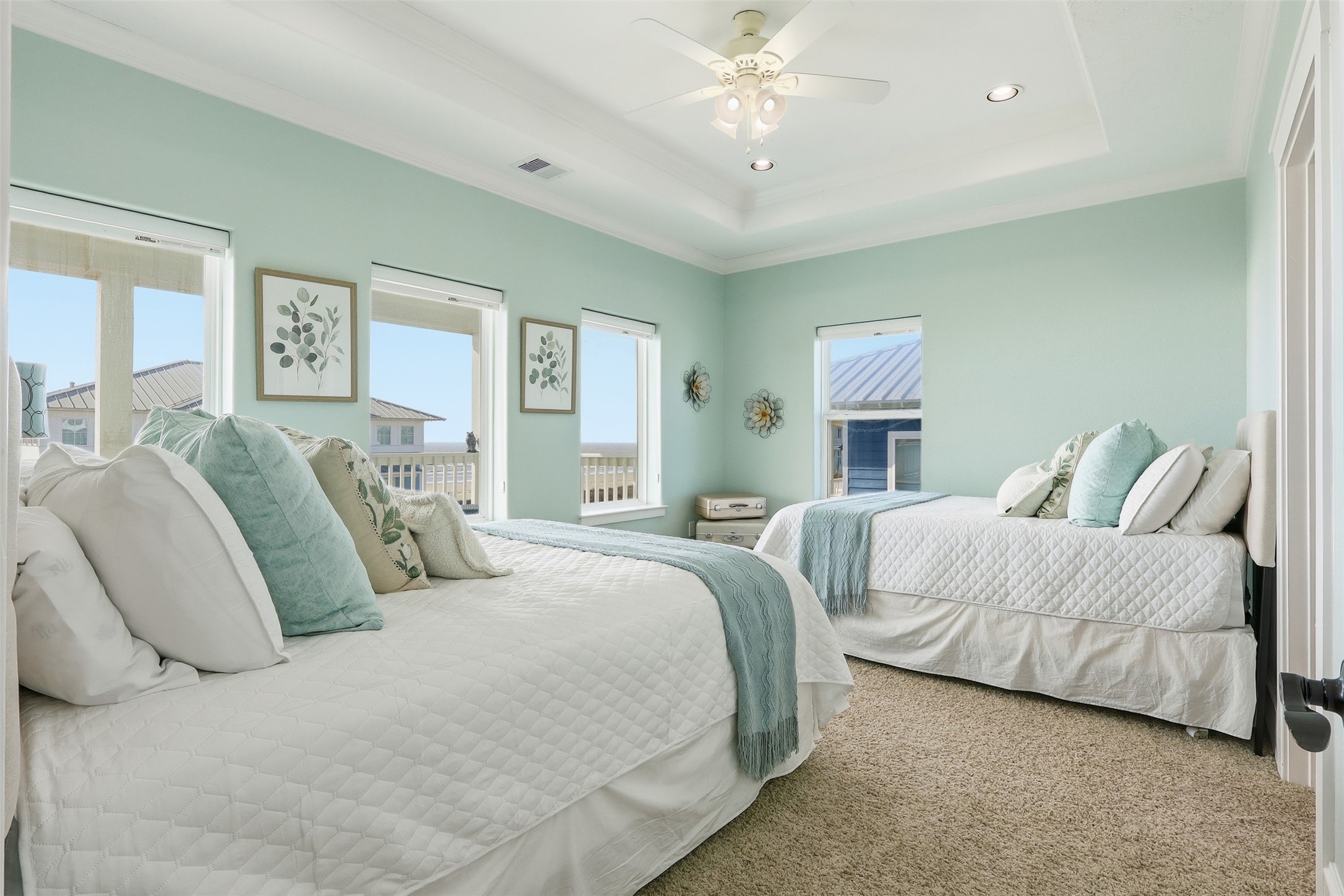 11622 Beachside Galveston, TX 77554 - Photo 16 of 39 This bedroom features a serene, coastal décor with two cozy beds and abundant natural light from multiple windows.