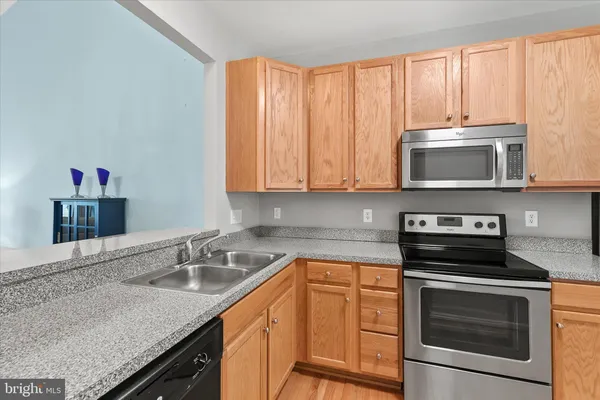a kitchen with stainless steel appliances granite countertop a sink stove and microwave