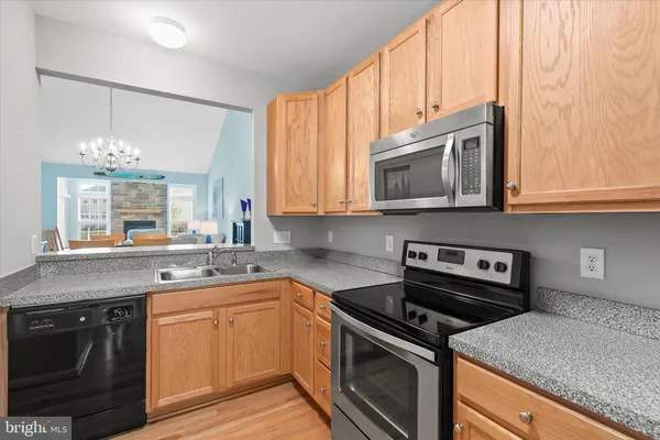 a kitchen with stainless steel appliances granite countertop a sink stove and microwave