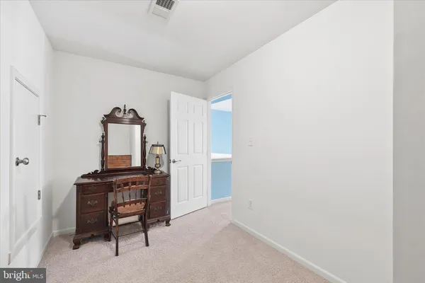 a bedroom with a bed and a lamp on dresser