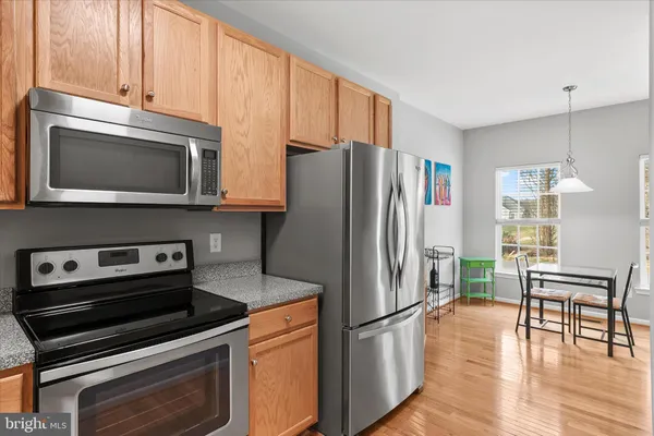 a kitchen with granite countertop a refrigerator stove and microwave