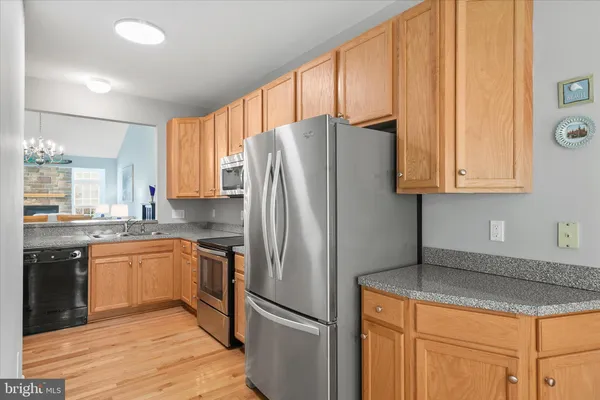 a kitchen with granite countertop stainless steel appliances a refrigerator cabinets and a sink