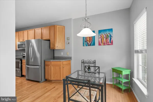 a kitchen with stainless steel appliances granite countertop a refrigerator a sink a stove and a wooden floors