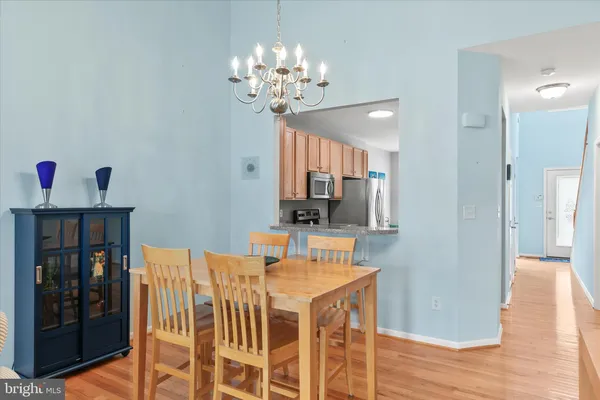 a view of a dining room with furniture a chandelier and wooden floor