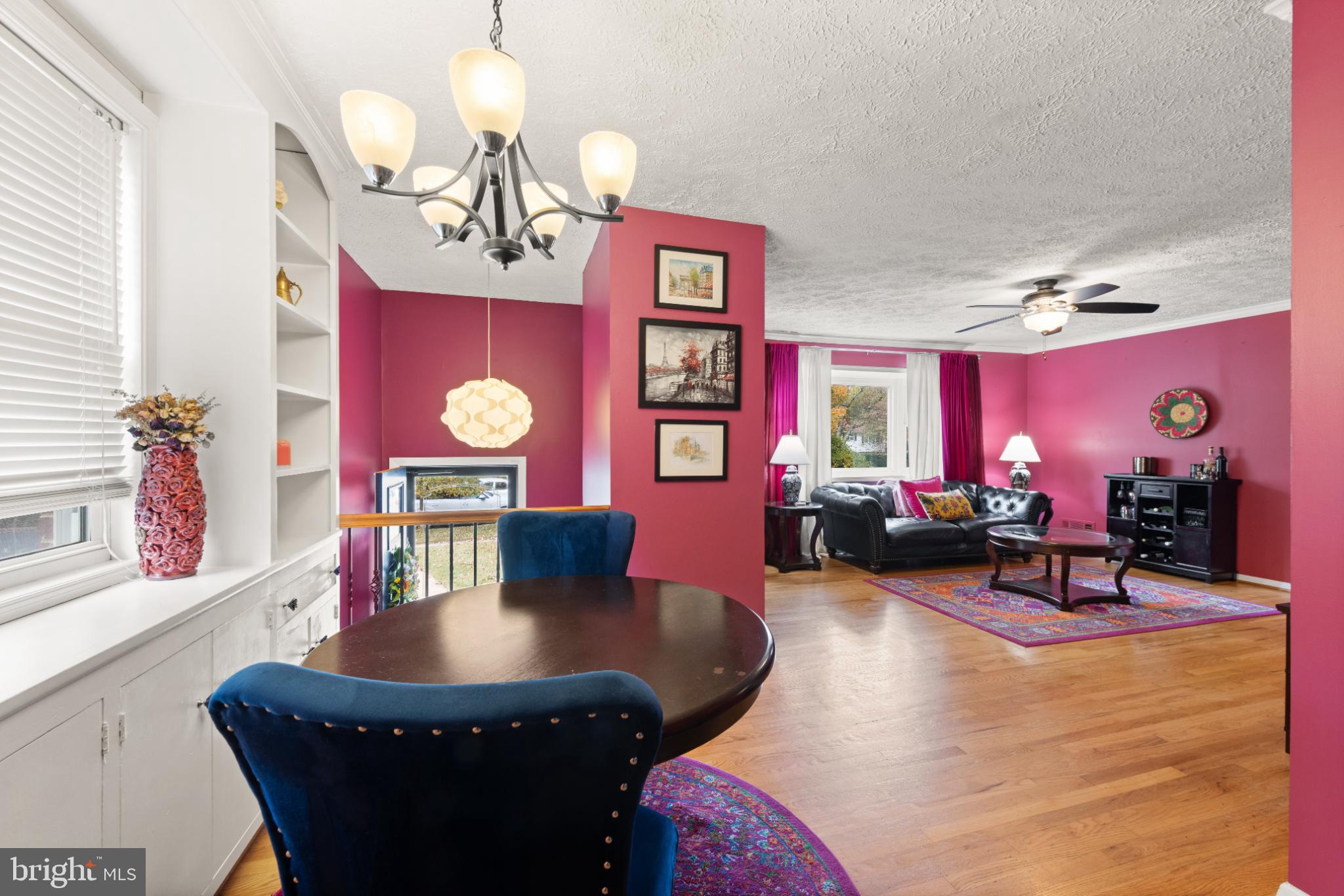 3700 Ralph Road Silver Spring, MD 20906 - Photo 27 of 30 a living room with furniture a dining table and paintings on the wall with wooden floor