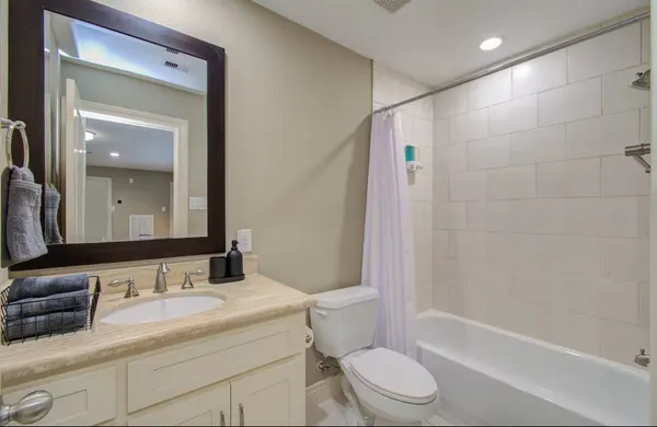 a bathroom with a granite countertop sink a toilet and shower