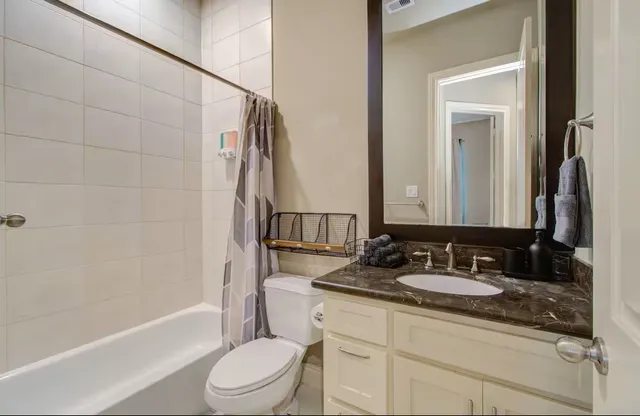 a bathroom with a granite countertop sink toilet and shower