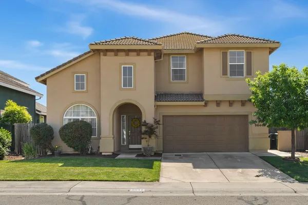 a front view of a house with a yard and garage