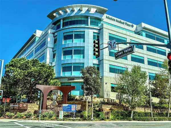 a view of a building with a large space and large trees