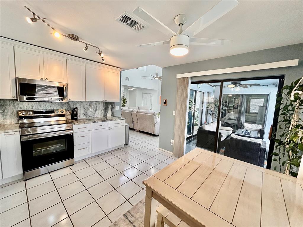 8911 Welsh Way Hudson, FL 34667 - Photo 13 of 33 a kitchen with stainless steel appliances and white cabinets