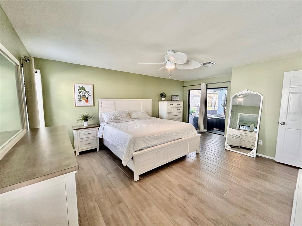 8911 Welsh Way Hudson, FL 34667 - Photo 17 of 33 a bedroom with a large bed and a large window