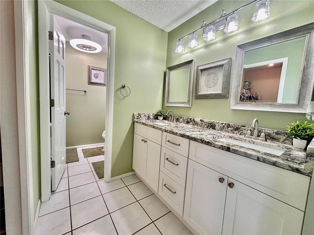8911 Welsh Way Hudson, FL 34667 - Photo 18 of 33 a spacious bathroom with a granite countertop sink mirror and a toilet