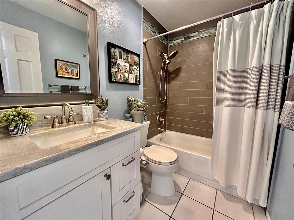8911 Welsh Way Hudson, FL 34667 - Photo 24 of 33 a bathroom with a granite countertop sink toilet mirror and shower