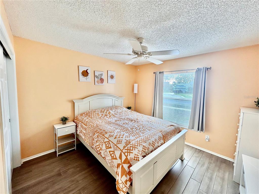 8911 Welsh Way Hudson, FL 34667 - Photo 25 of 33 a bedroom with a bed and wooden floor