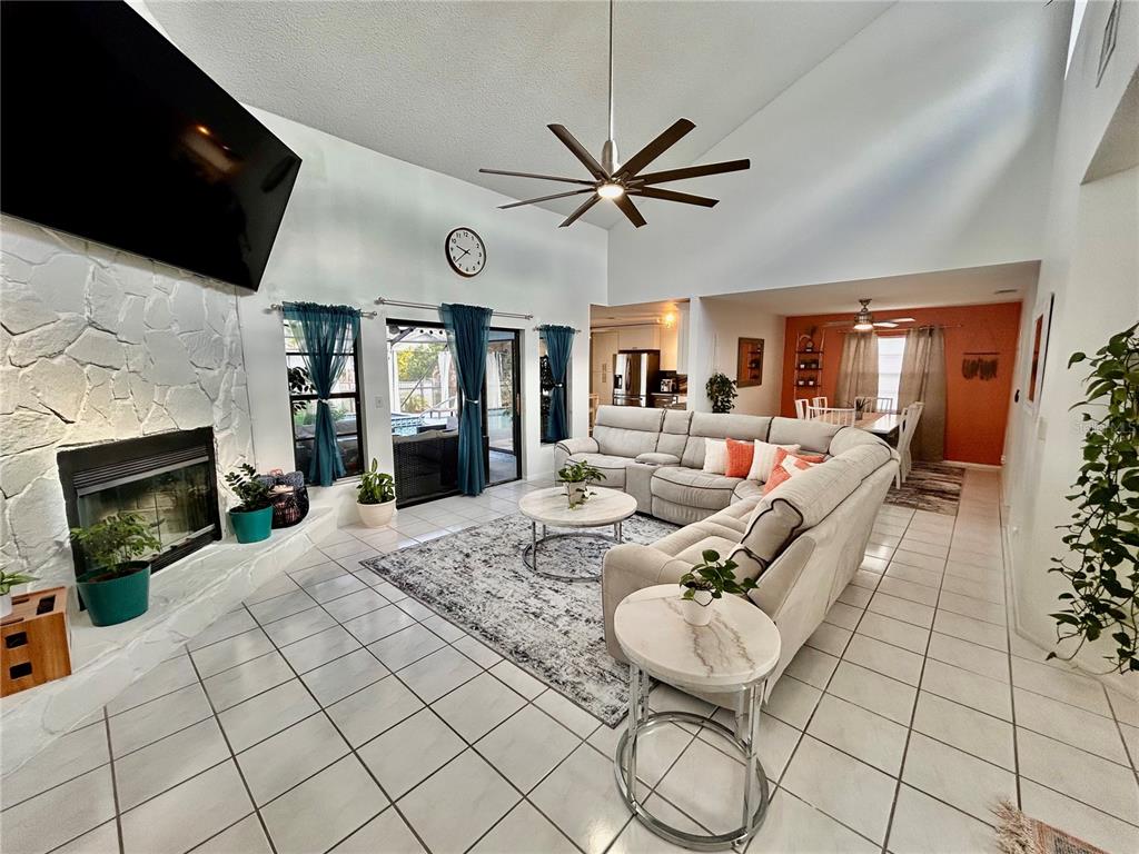 8911 Welsh Way Hudson, FL 34667 - Photo 4 of 33 a living room with furniture a flat screen tv and a fireplace