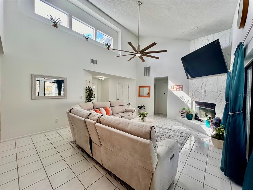 8911 Welsh Way Hudson, FL 34667 - Photo 6 of 33 a living room with furniture a flat screen tv and a fireplace