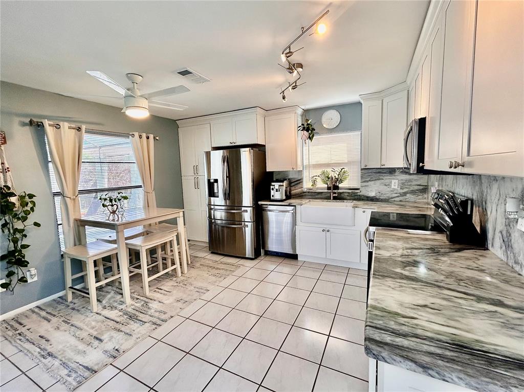8911 Welsh Way Hudson, FL 34667 - Photo 9 of 33 a kitchen with granite countertop a sink appliances cabinets and furniture